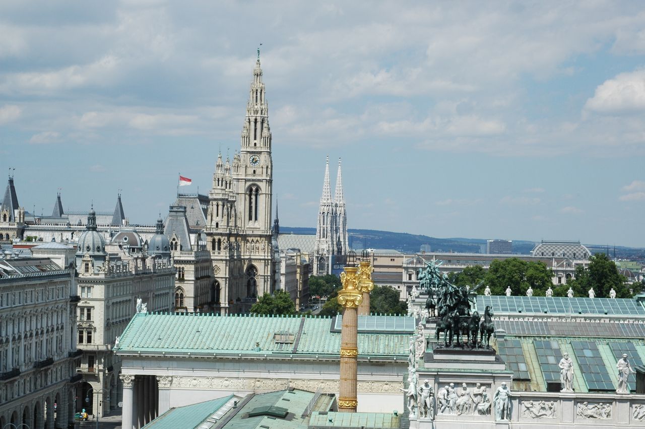 Aerial view of Vienna showcasing the town hall, Votivkirche, and architectural landmarks.