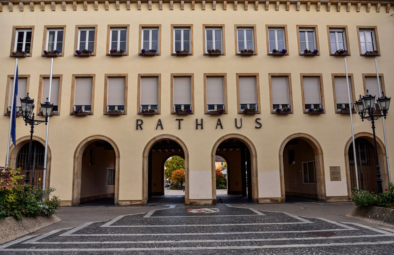 About Exterior view of the Rathaus building in Frankenthal, Germany, showcasing its architectural arches and facade.